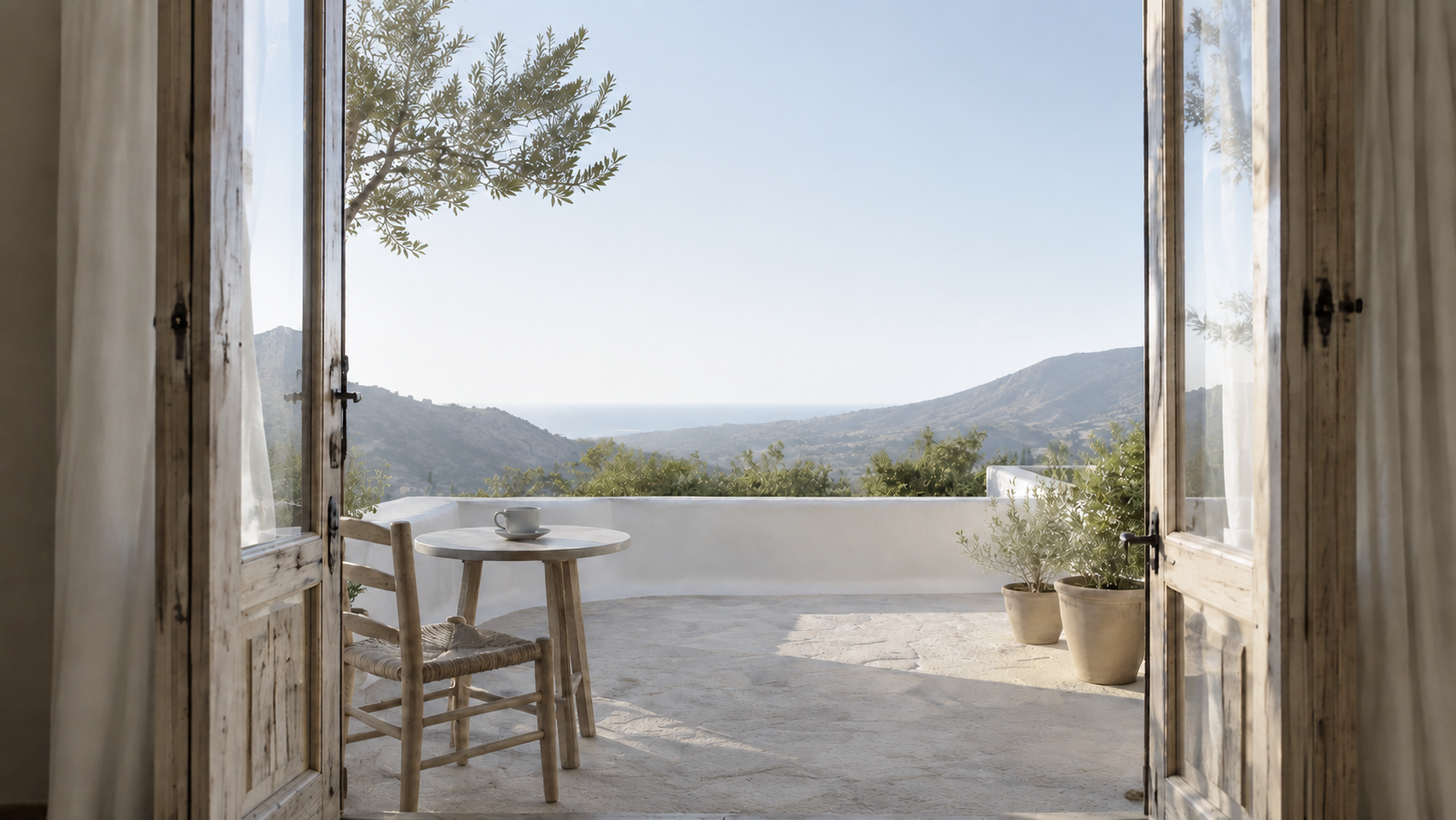 A bright morning terrace with coffee, mountain views and the sea in the distance